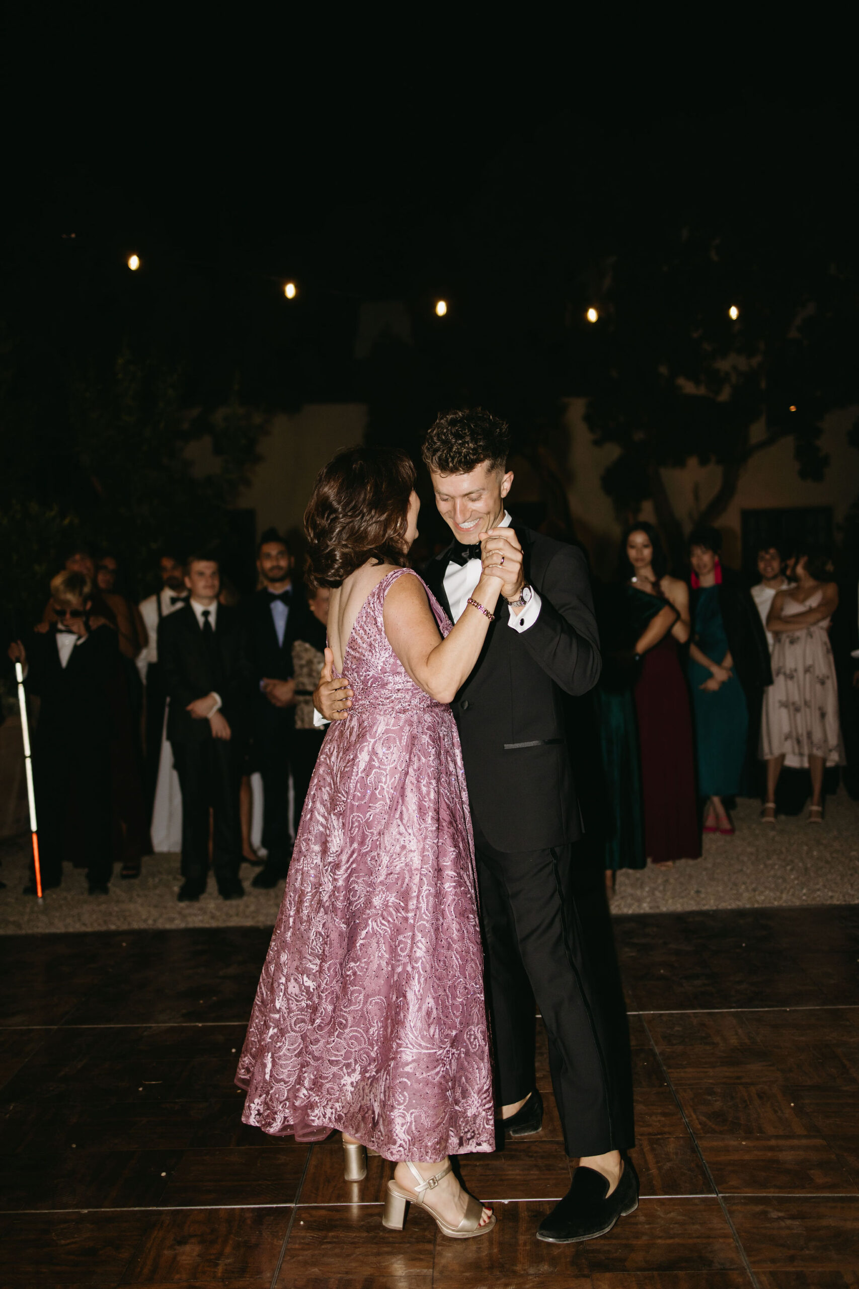 Guests enjoy dancing at a wedding reception at a private residence for a backyard wedding 