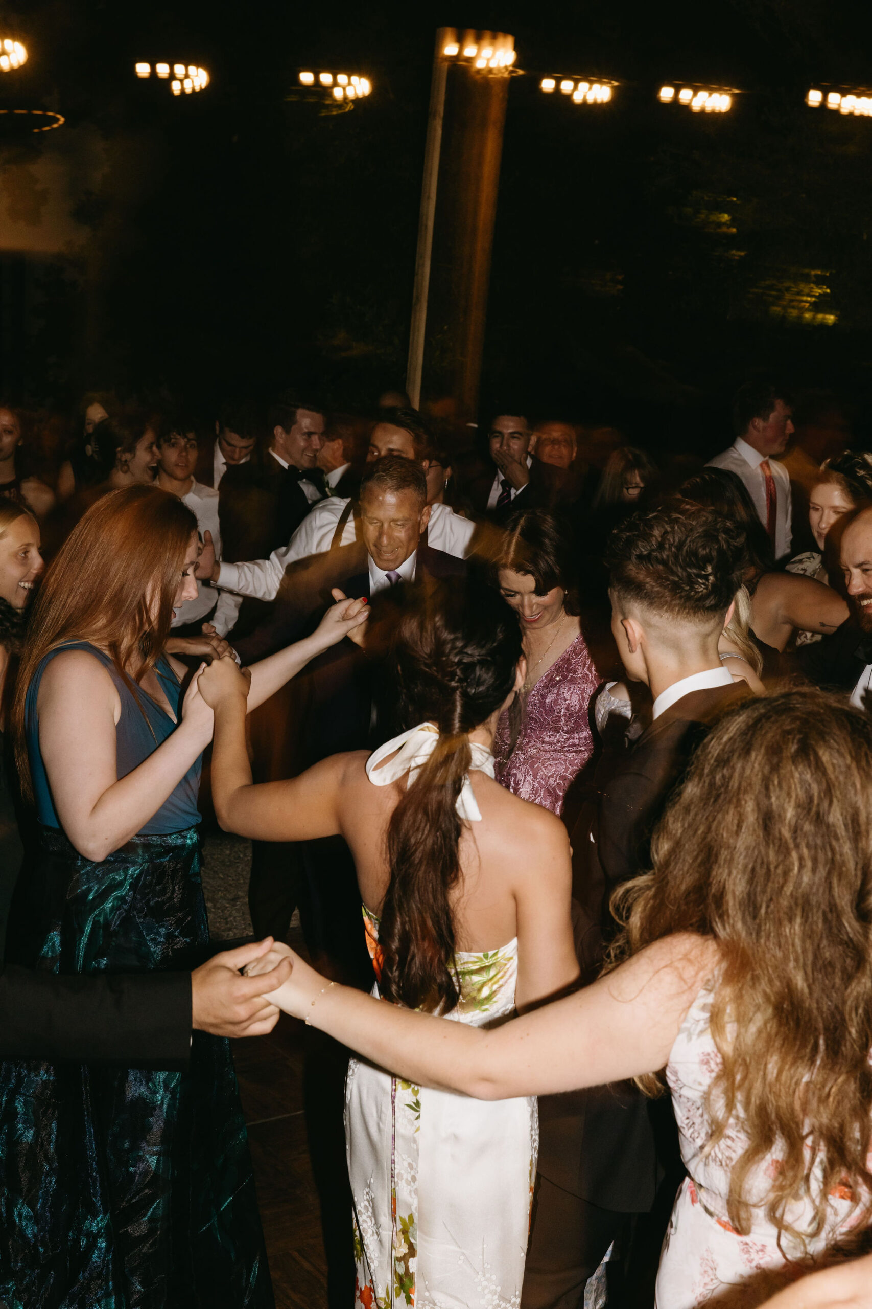 Guests enjoy dancing at a wedding reception at a private residence for a backyard wedding 