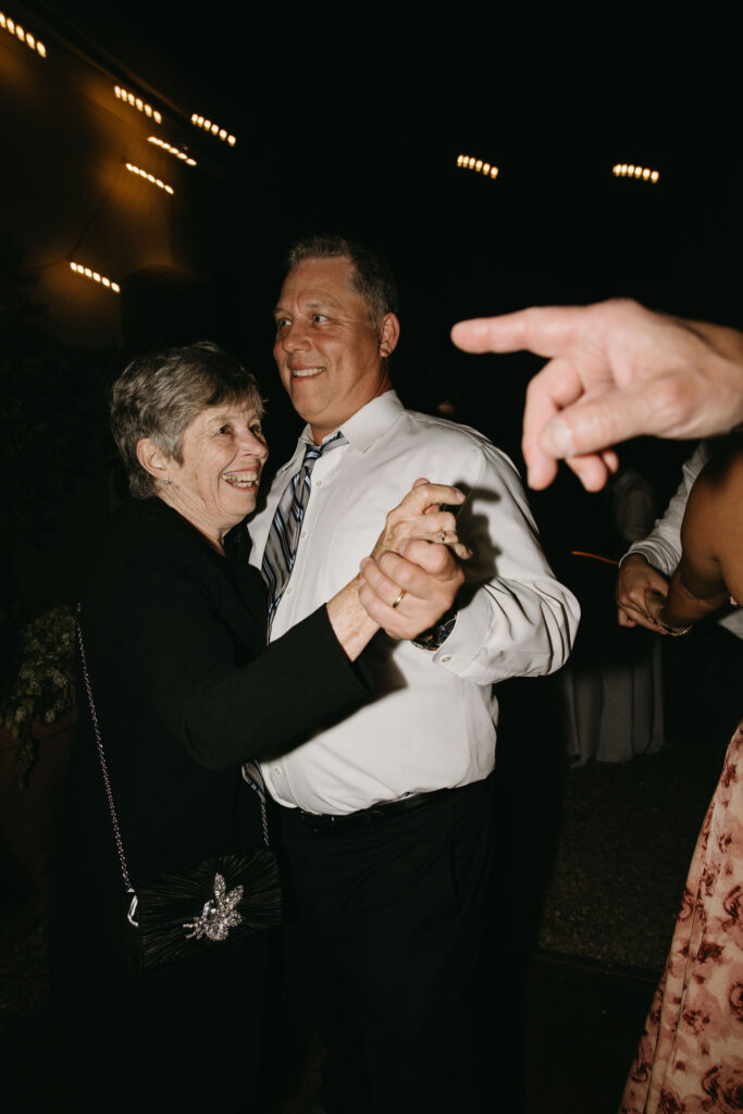 couple cuts cake at their wedding reception at a private residence for a backyard wedding 