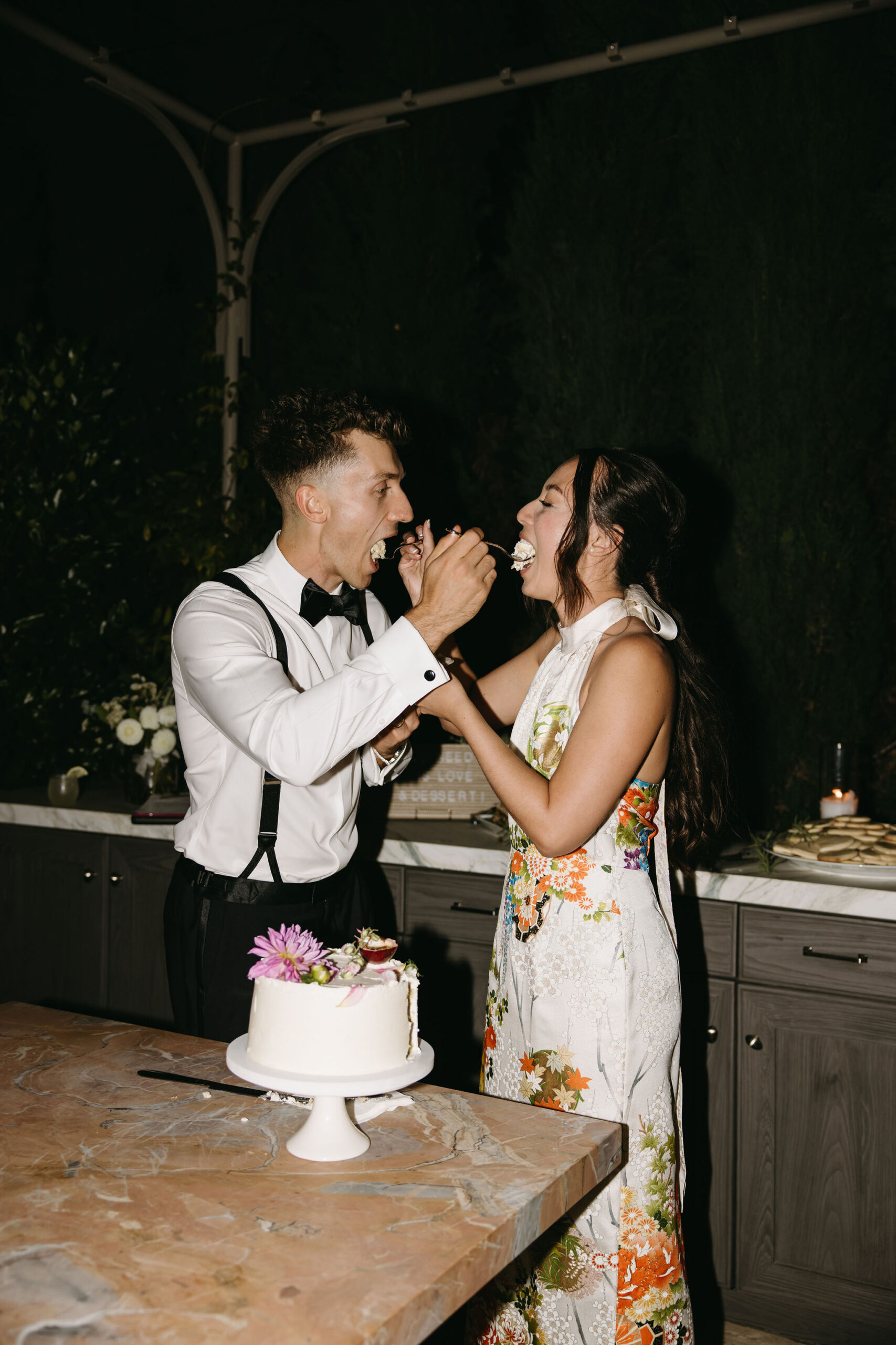 couple cuts cake at their wedding reception at a private residence for a backyard wedding 