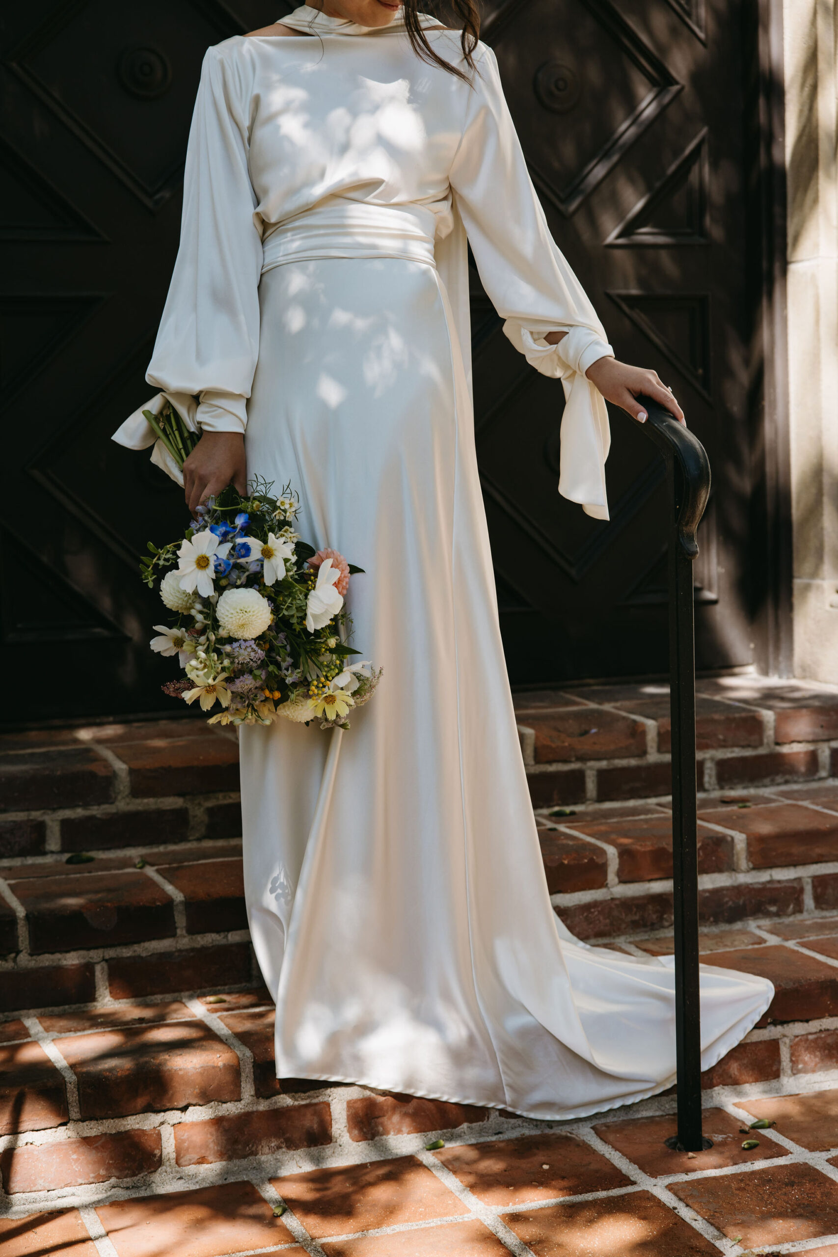 bride holding a bouquet walking down a staircase | documentary style wedding photos