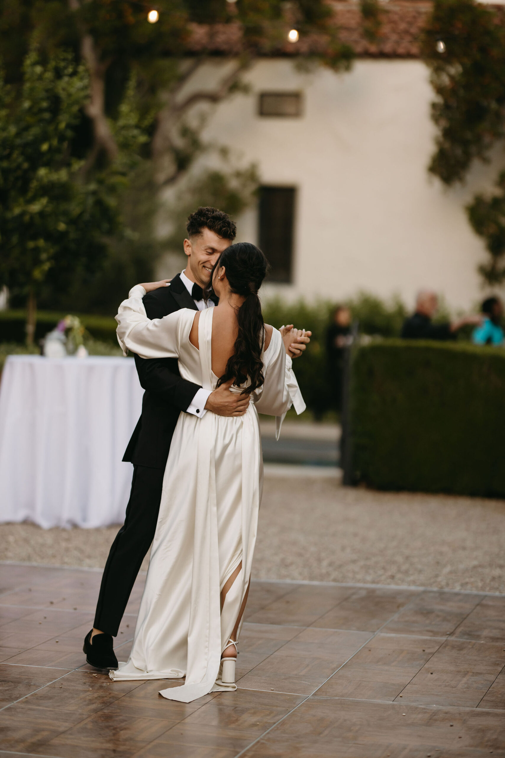 bride and groom take their documentary style wedding photos  outdoors as they do their first dance