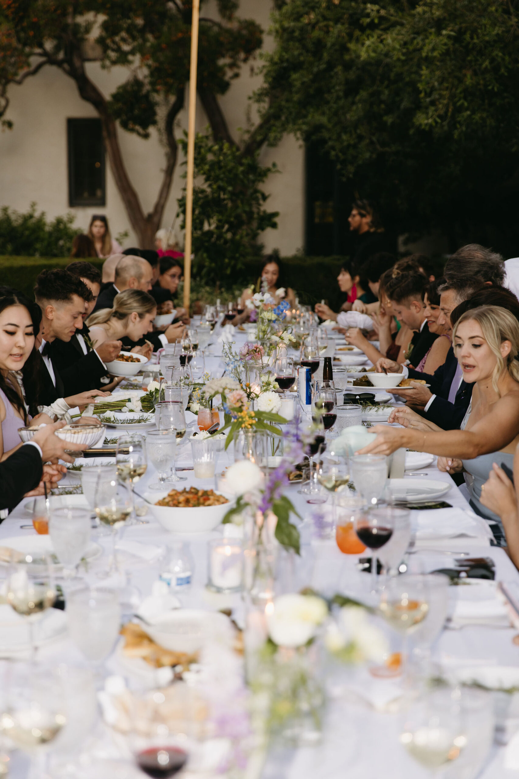 Guests enjoy a wedding reception at a private residence for a backyard wedding 