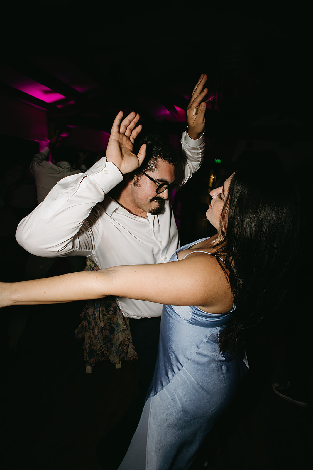 People dancing energetically at a party, wearing formal attire, in a black and white photograph.