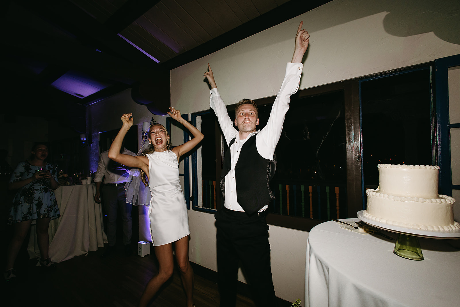 People dancing energetically at a party, wearing formal attire, in a black and white photograph.