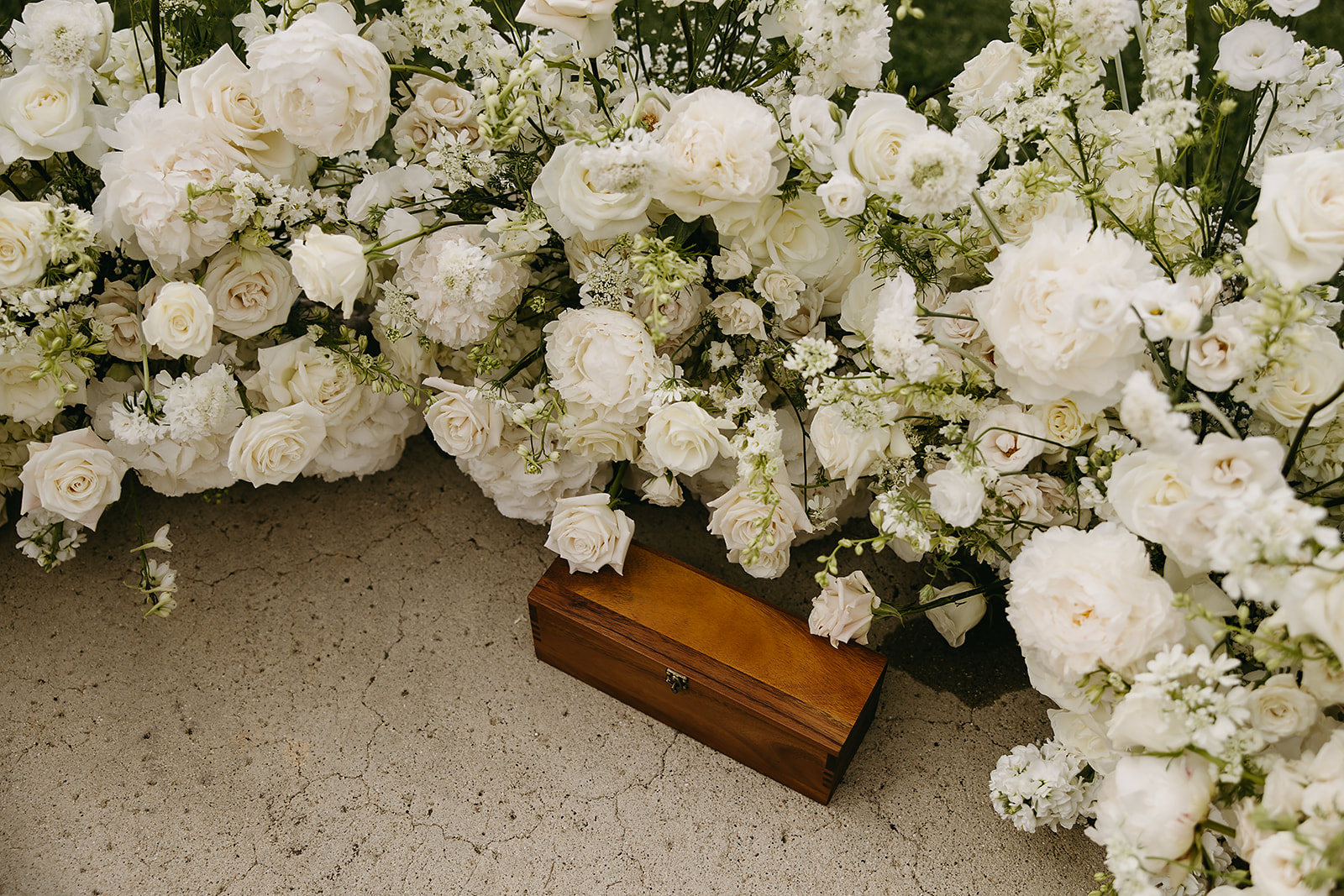 An outdoor wedding ceremony setup with wooden chairs arranged in rows facing an altar adorned with white flowers, overlooking a scenic ocean view under a clear sky at La Venta Inn