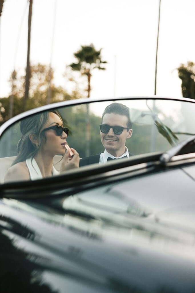 man and woman take engagement photos in LA outdoors by a vintage car