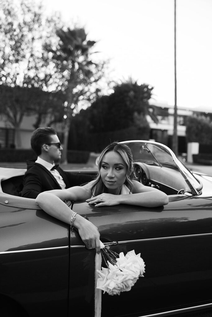 man and woman take engagement photos in LA outdoors by a vintage car