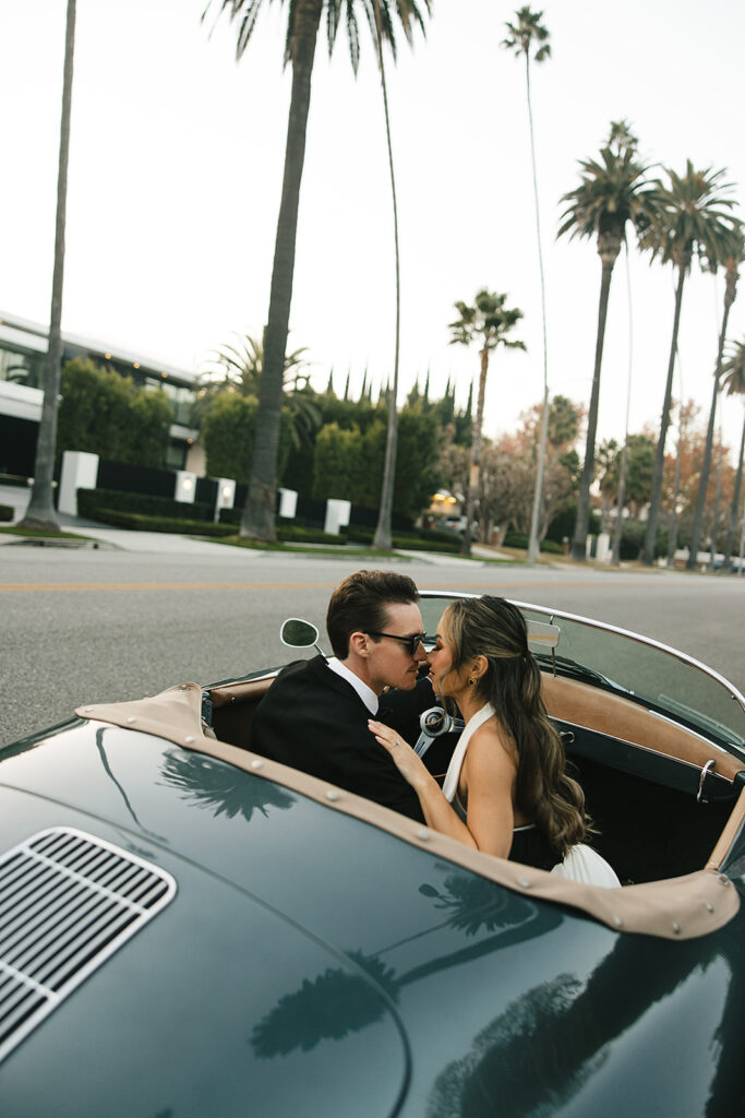 man and woman take engagement photos in LA outdoors by a vintage car