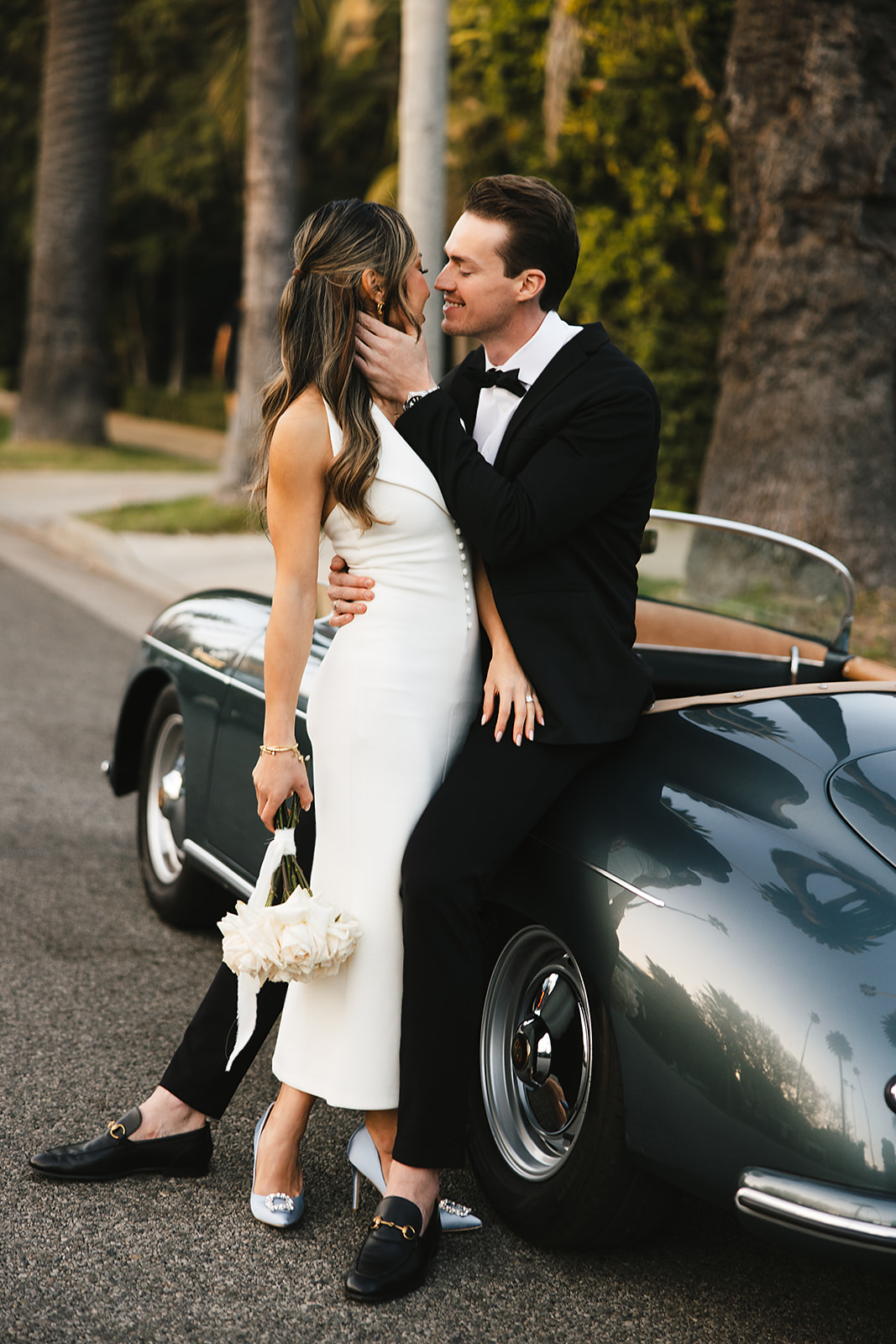 man and woman take engagement photos in LA outdoors by a vintage car