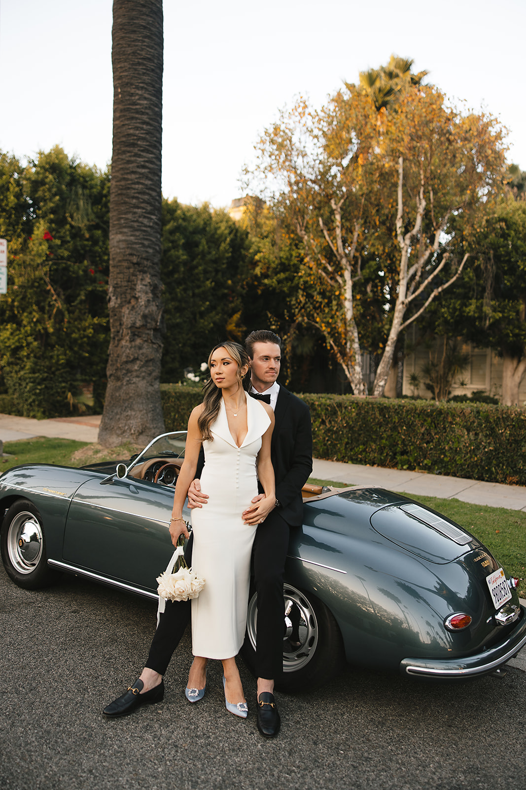 man and woman take engagement photos in LA outdoors by a vintage car