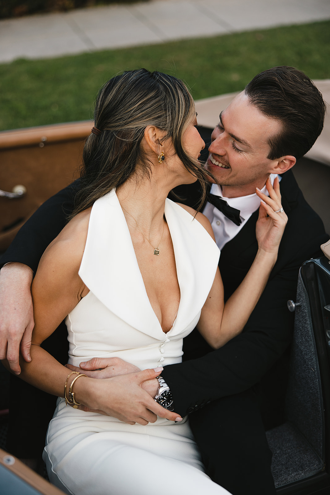 man and woman take engagement photos in LA outdoors by a vintage car