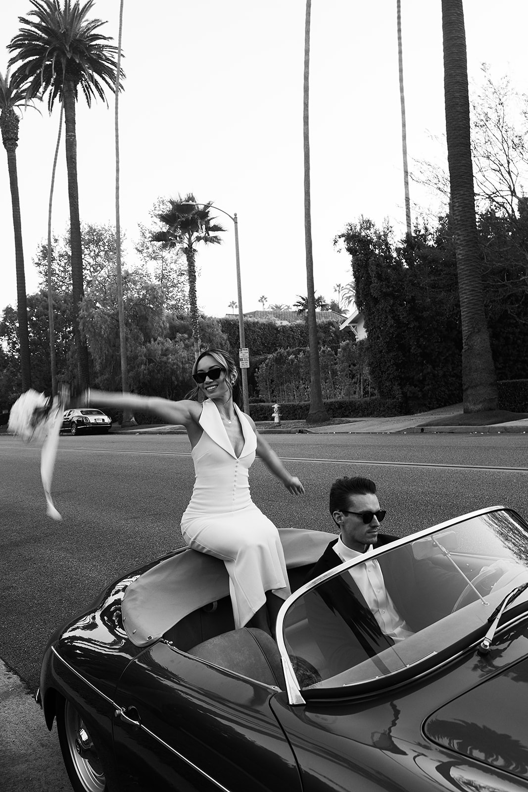 man and woman take engagement photos in LA outdoors by a vintage car