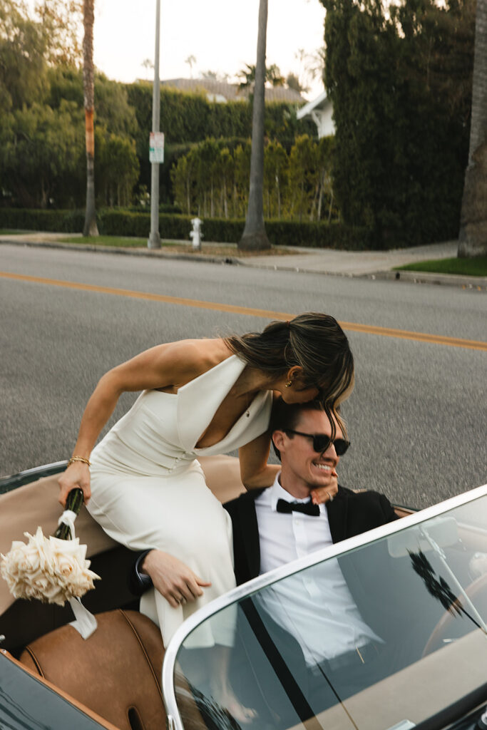 man and woman take engagement photos in LA outdoors by a vintage car