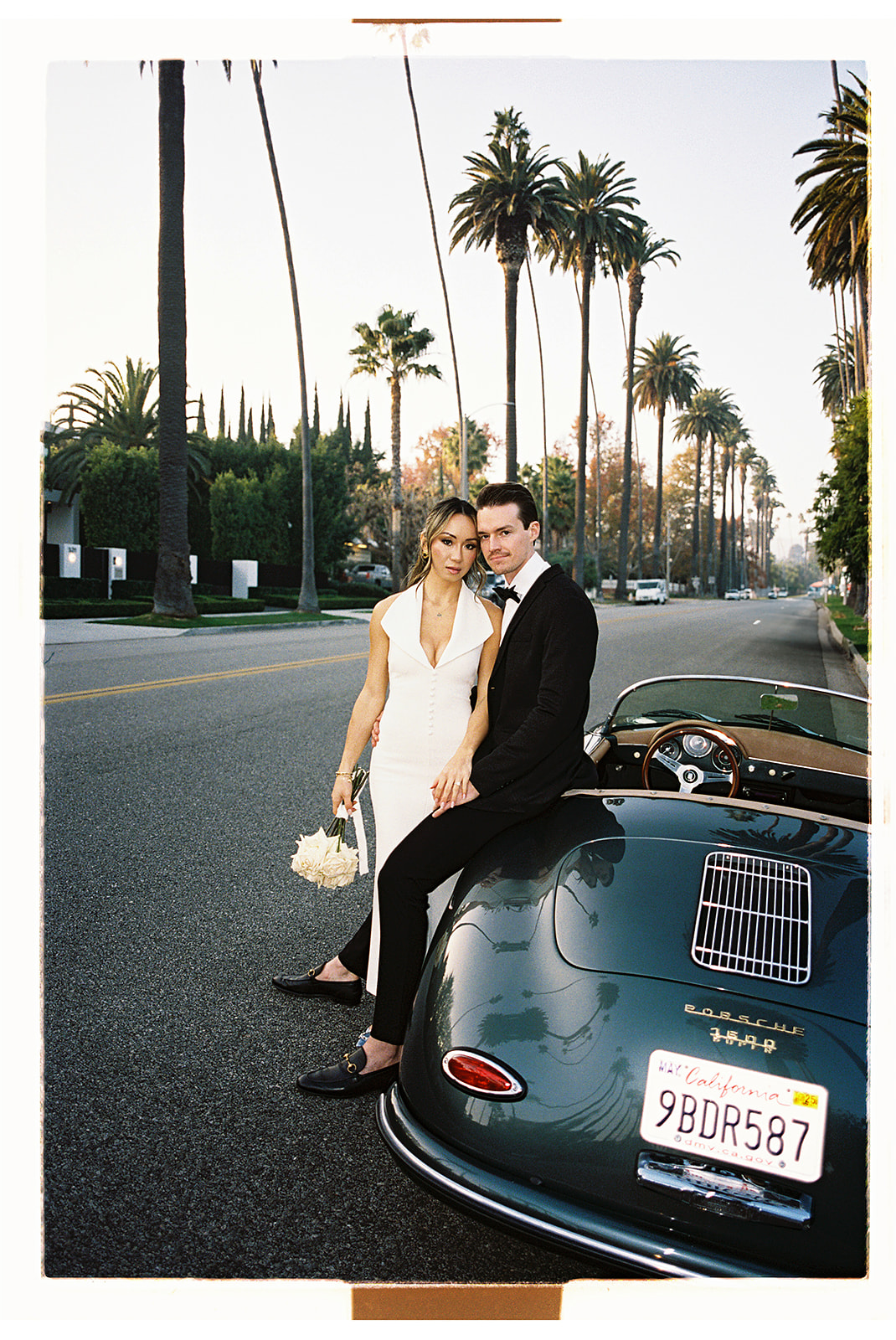 man and woman take engagement photos in LA outdoors by a vintage car