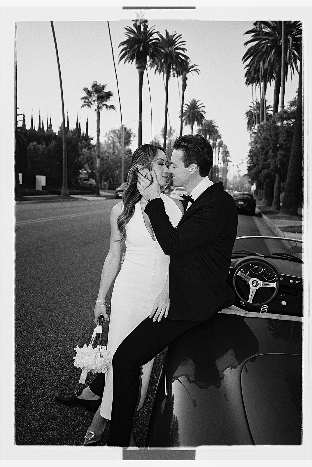 man and woman take engagement photos in LA outdoors by a vintage car