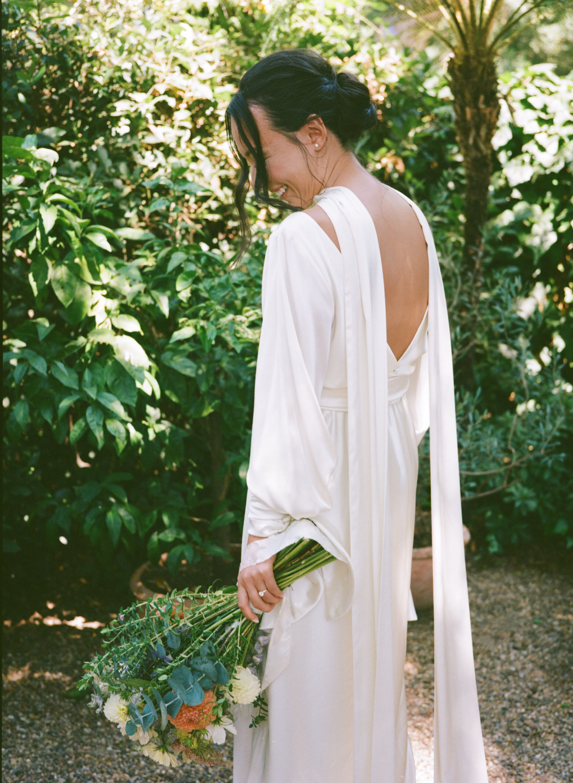 bride holding a bouquet at her wedding outdoors as she looks down