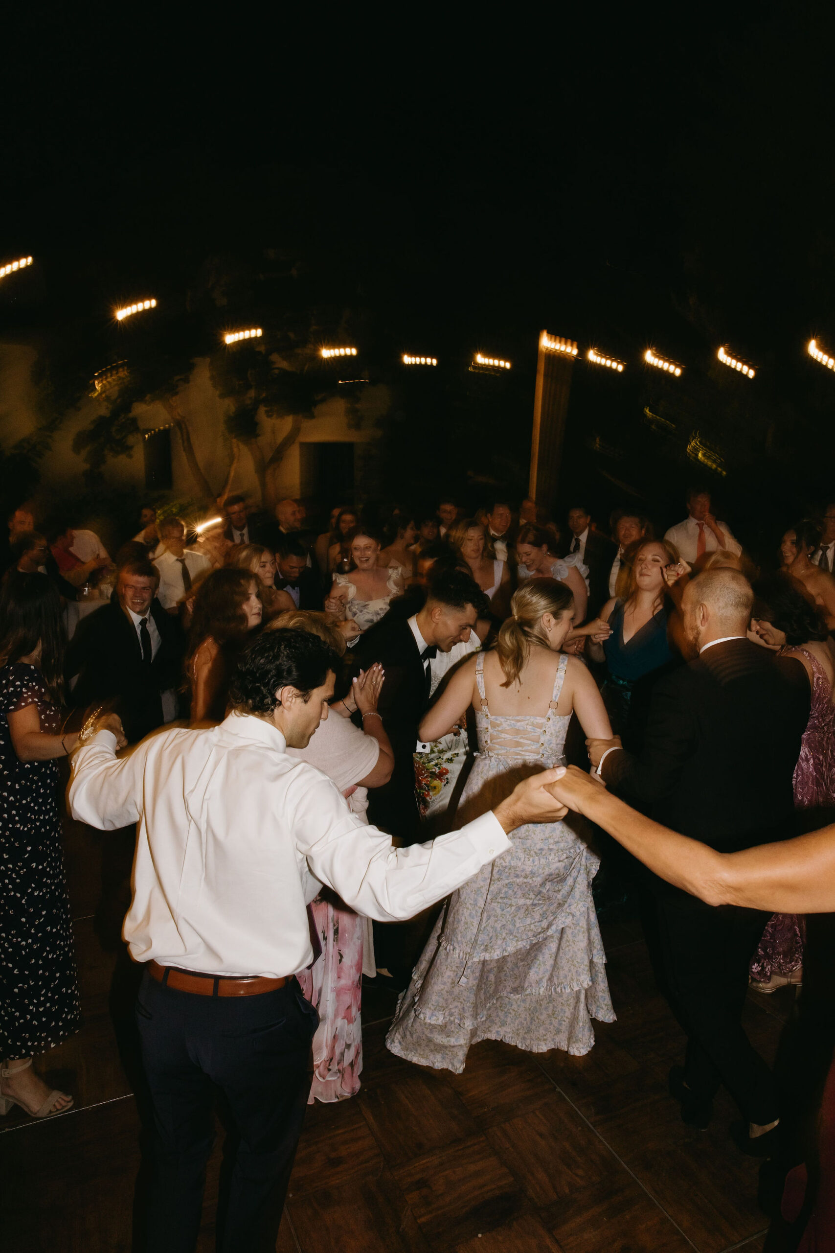 Guests enjoy dancing at a wedding reception at a private residence for a backyard wedding 