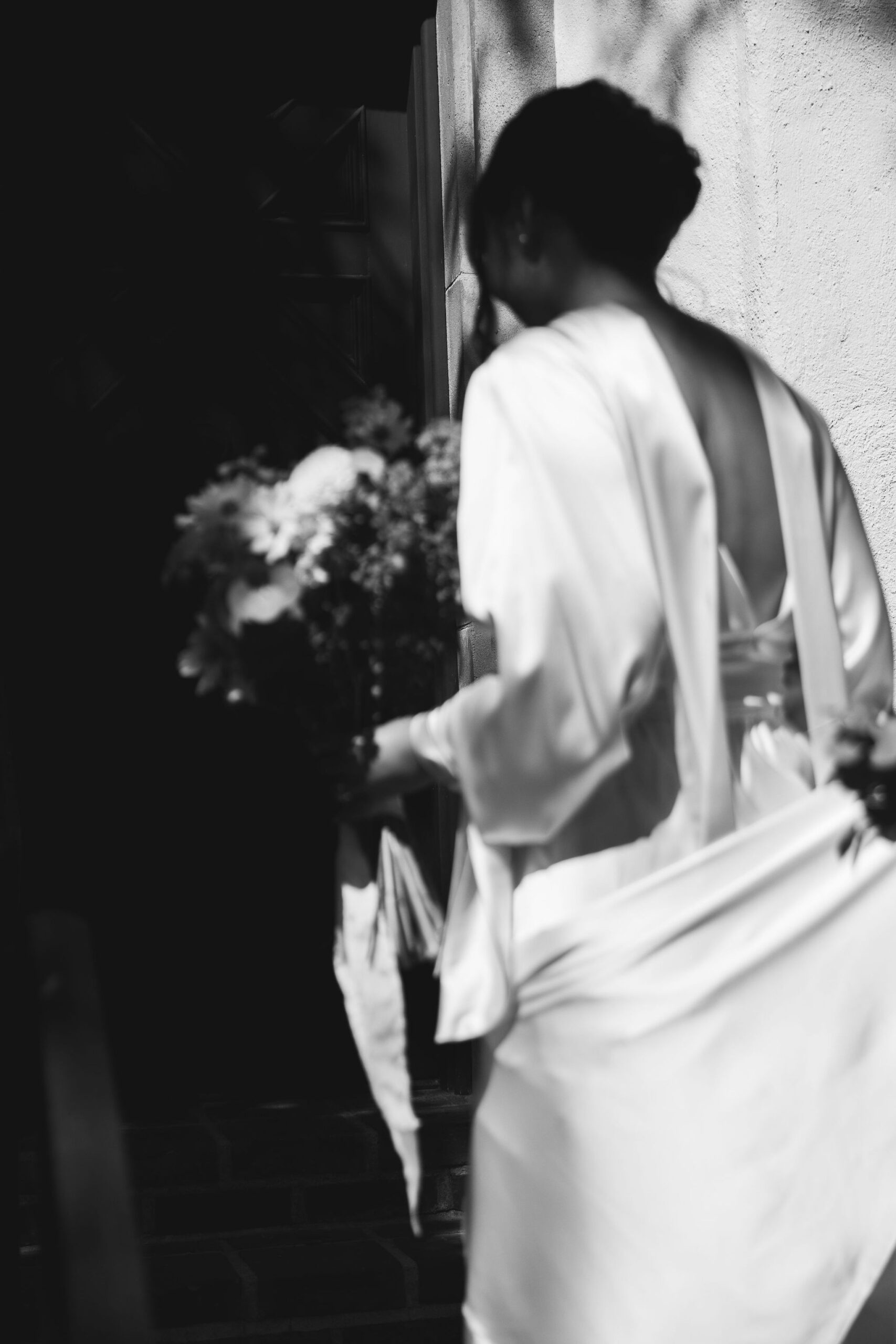 bride holding a bouquet walking down a staircase | documentary style wedding photos