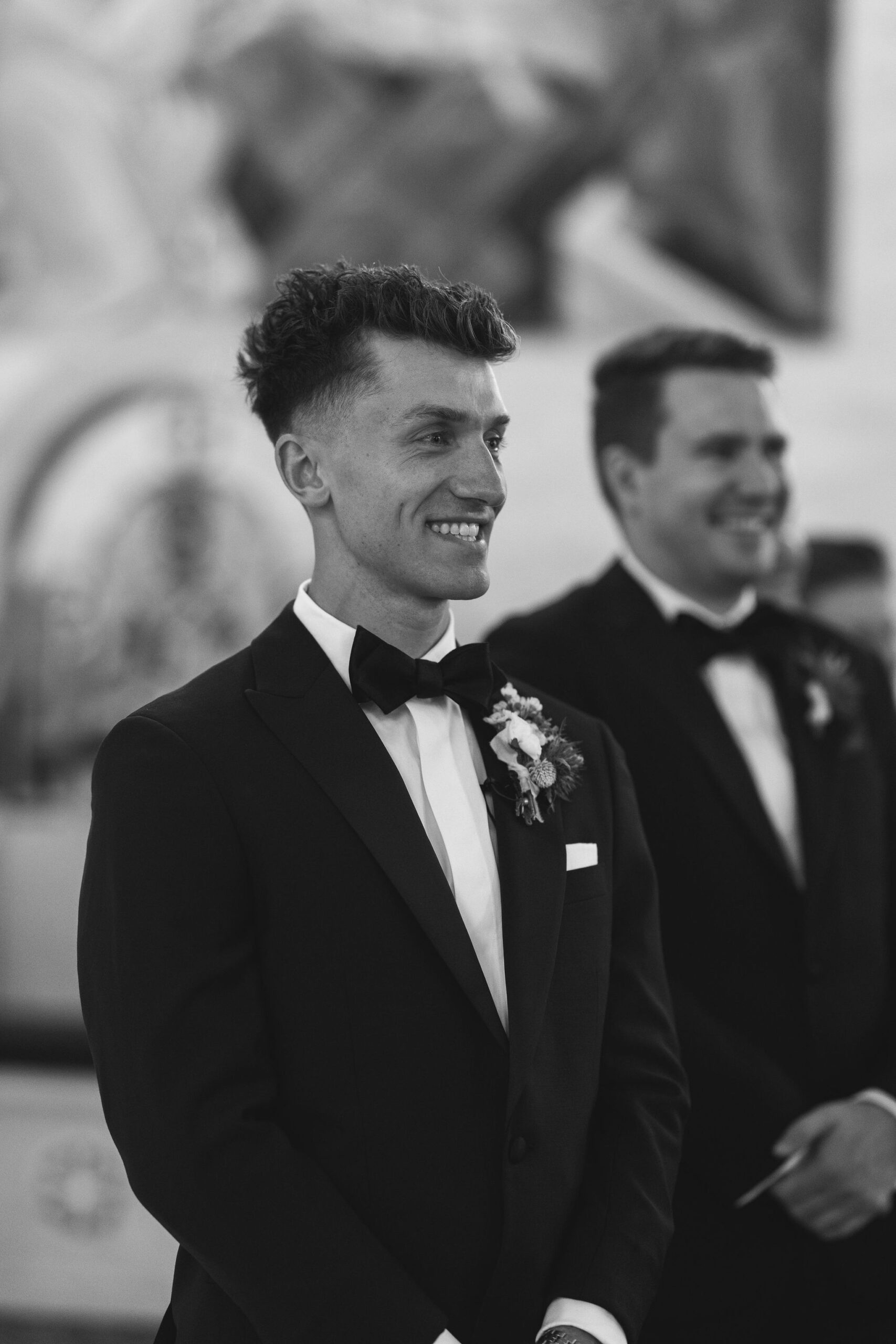 Groom waits for bride at the end of the alter at a church