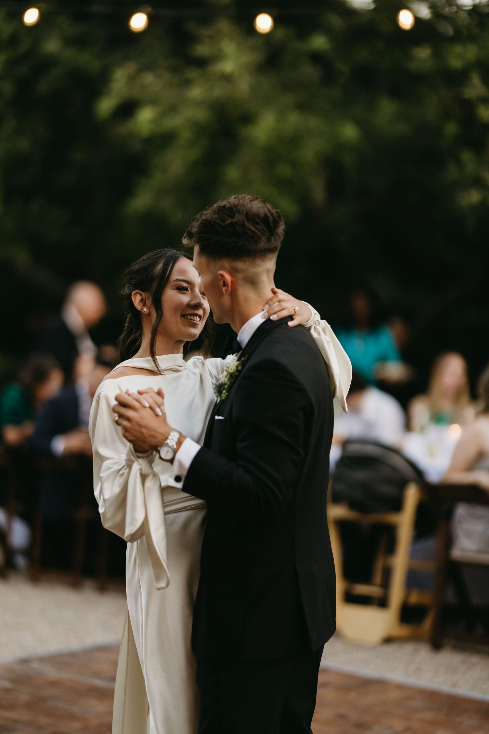 bride and groom take their documentary style wedding photos outdoors as they do their first dance