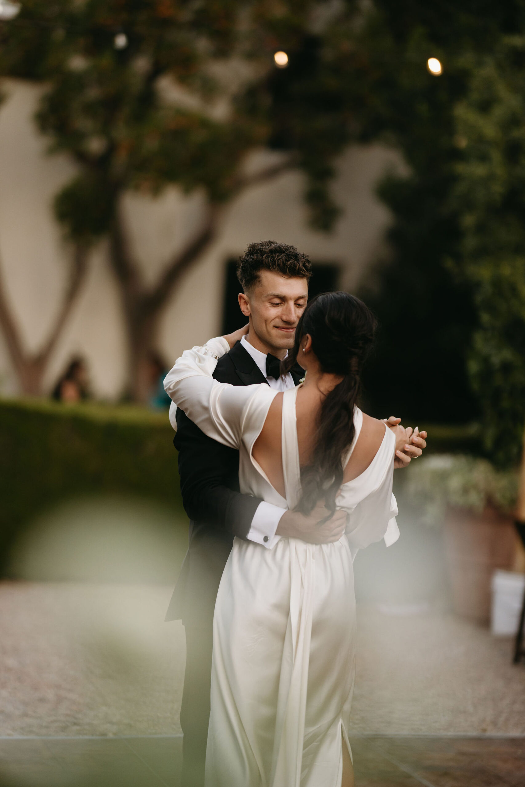 bride and groom take their documentary style wedding photos outdoors as they do their first dance