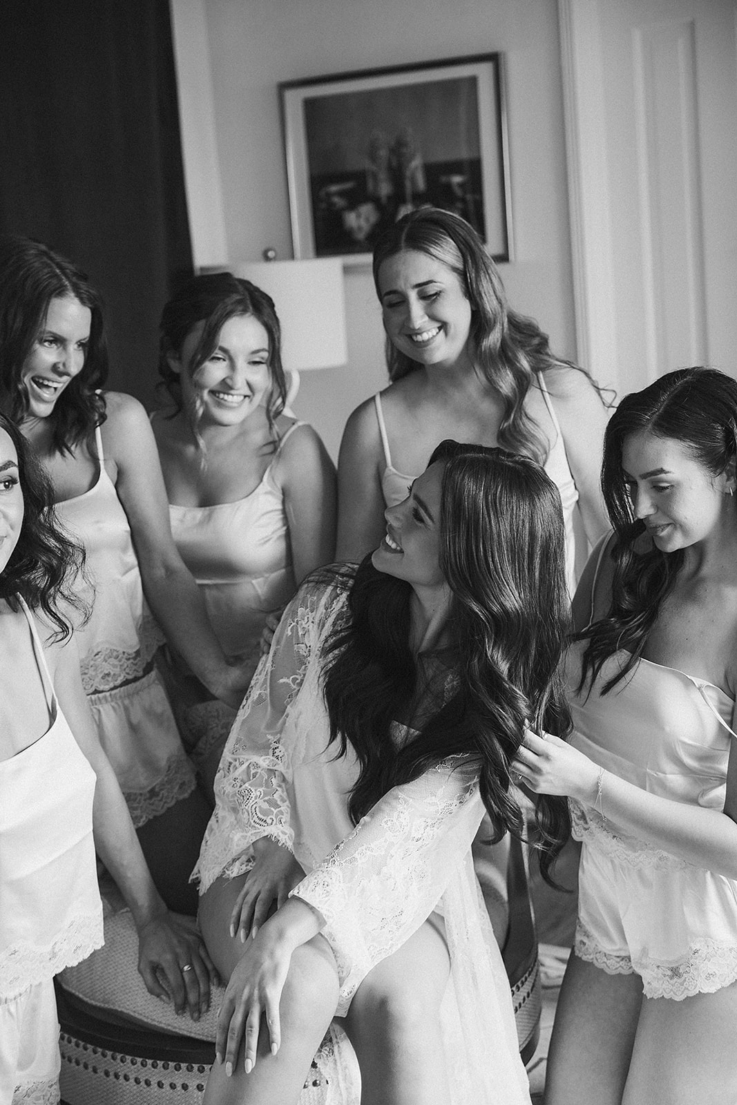  A group of bridesmaid in matching light blue attire pose indoors on a rug, with one holding a small dog for a wedding at the La Venta Inn